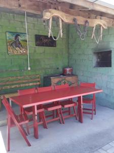 皮拉图巴Casa aconchegante em estilo rústico的红色野餐桌,红色椅子,在房间