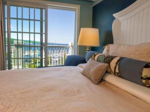 沃特金斯格伦沃特金斯峡谷海港酒店的女人躺在卧室的床上,卧室里设有窗户