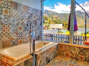 圣佩德罗拉拉古纳TIBERIAS by luxury Atitlan的带浴缸的浴室和窗户