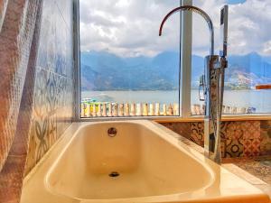 圣佩德罗拉拉古纳TIBERIAS by luxury Atitlan的带浴缸的浴室和窗户