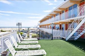 威尔伍德克拉斯特格拉纳达海洋度假胜地汽车旅馆的在酒店阳台上摆放一排白色椅子