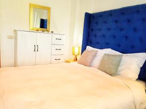 圣佩德罗拉拉古纳VENICE by luxury Atitlan的一间卧室配有一张大床和蓝色床头板