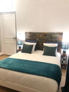 亚眠Ginkgo Maison d'hôtes的一间卧室设有一张带砖墙的大床