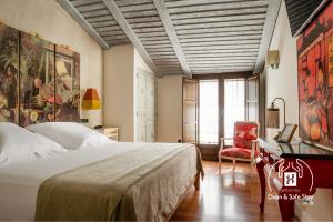 巴埃萨YIT La Casona del Arco的卧室配有1张床、1张桌子和1把椅子