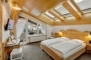 采尔马特安提卡酒店的一间带一张大床的卧室,位于带天窗的房间