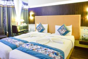 海得拉巴住宅品质酒店的一间酒店客房,房间内设有两张床