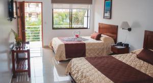 雅科Hotel Arenas en Punta Leona的酒店客房设有两张床和窗户。