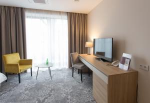 克罗斯诺Polanka Conference Center的酒店客房设有一张书桌,电视