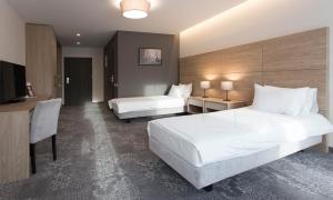 克罗斯诺Polanka Conference Center的酒店客房配有两张床和一张书桌
