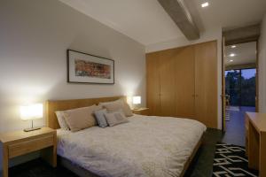 瓜达拉哈拉Apartamentos Buenos Aires的一间卧室配有一张带两盏灯和一扇门的床。
