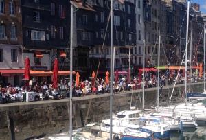 翁弗勒尔Les logettes的一群人坐在码头上,坐船