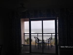 默特尔比奇大洋礁度假酒店的客房设有带桌椅的阳台。