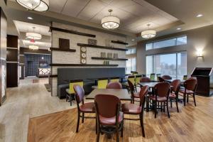 比奇伍德Drury Inn & Suites Cleveland Beachwood的一间在房间内配有桌椅的餐厅