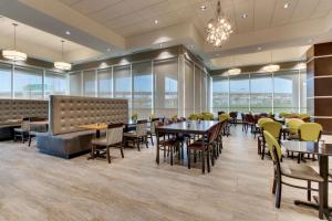 理查森Drury Plaza Hotel Dallas Richardson的用餐室设有桌椅和窗户。