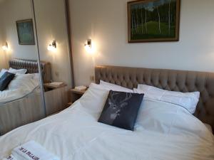 兹拉蒂博尔Apartment de La Falaise-Aпартмaн де Лa Фалез的卧室配有白色的床,上面有猫枕头