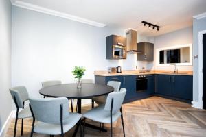 都柏林Staycity Aparthotels, Dublin, Christchurch的厨房配有蓝色橱柜和桌椅