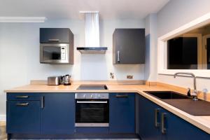 都柏林Staycity Aparthotels, Dublin, Christchurch的厨房配有蓝色橱柜和水槽