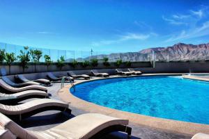 科皮亚波纳特依赌场酒店的一个带躺椅的游泳池,享有山景