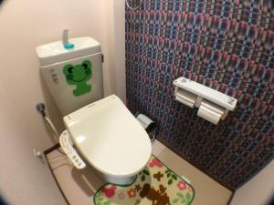 大阪Shoyaya Hostel的一间小浴室,内设带绿色标签的卫生间