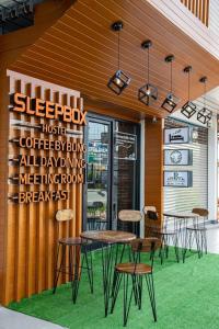 素叻Sleepbox Hostel Suratthani的一群桌子和椅子在餐厅外