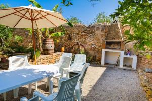 圣米克尔德巴兰4 bedrooms villa with private pool enclosed garden and wifi at Sant Miquel de Balansat 5 km away from the beach的桌椅、雨伞和壁炉