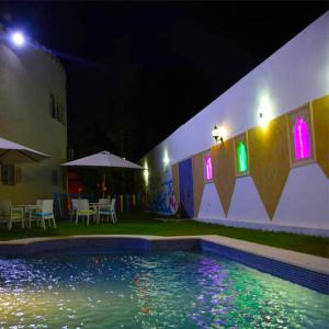 莫纳斯提尔5 bedrooms villa at Monastir 200 m away from the beach with private pool enclosed garden and wifi的一座游泳池,在晚上在建筑物前