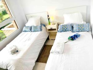 桑托尼亚2 bedrooms appartement at Santona 500 m away from the beach with balcony的两张睡床彼此相邻,位于一个房间里