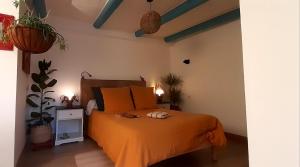 ElliantNuances bretonnes的一间卧室配有一张带橙色床罩的床