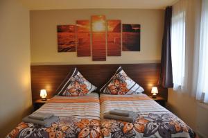 罗斯托克乌尔施普龙公寓 的一间卧室配有一张带两盏灯和两张照片的床。