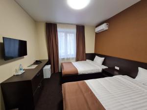 波尔塔瓦EVEREST ОТЕЛЬ的酒店客房设有两张床和一台平面电视。