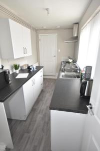 特伦特河畔斯托克Townhouse @ Penkhull New Road Stoke的厨房配有白色橱柜和水槽