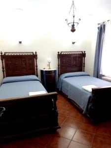 罗德里戈城6 bedrooms house with enclosed garden at Ivanrey的一间卧室配有两张床和吊灯。