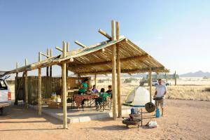 塞斯瑞姆Sossus Oasis Campsite的一群站在木亭下的人