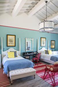 卡帕尔比奥洛坎达罗萨酒店的一间蓝色卧室,配有两张床和一张书桌