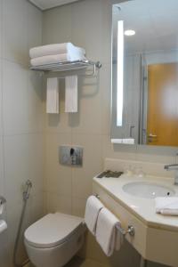 阿布扎比宜必思阿布扎比门酒店的一间带水槽、卫生间和镜子的浴室