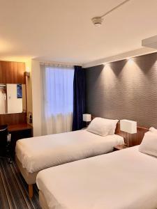 里尔快捷假日里尔中央酒店的酒店客房设有两张床和窗户。