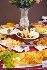 路易斯爱德华多马加良伊斯Pak Suítes Hotel的装满食物盘子和花瓶的桌子