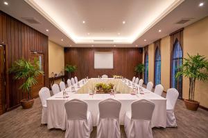 卡农Khanom Beach Resort And Spa的大型会议室,配有长桌子和白色椅子