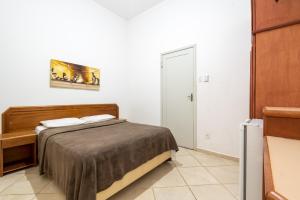 伊塔库鲁OYO Residencial Itacuruçá Apart Hotel的一间小卧室,配有一张床和一扇门