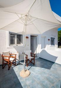 TriovasálosGiorgantis House & Studio的一个带椅子和桌子的庭院上的白色帐篷