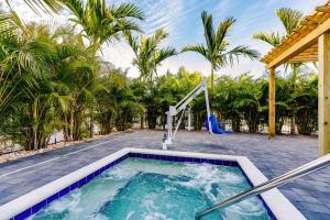 萨拉索塔Kompose Boutique Hotel Sarasota的棕榈树后院的游泳池,设有喷泉