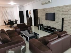 洛美Residence Galaxy Togo的带沙发和平面电视的客厅