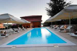 希洛Pension Riviera-Šilo的一个带椅子和遮阳伞的大型游泳池