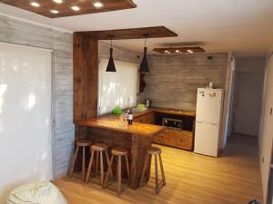 皮奇勒姆Costa Lobo的厨房配有带凳子的柜台和冰箱。