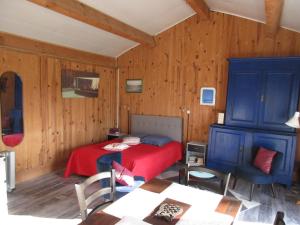 Sainte-OliveEspace Nature Studio indépendant proche du Parc des oiseaux的一间卧室配有红色的床和蓝色橱柜