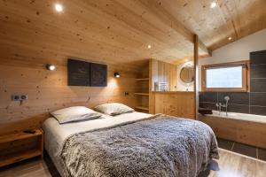 大博尔南Chalet Socali Le Grand Bornand的卧室配有床和浴缸