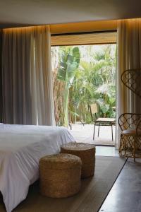 伊卡莱Makena Hotel的一间卧室设有一张床和一个带椅子的大窗户