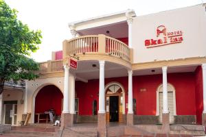 巴兰基亚Hotel Ayenda Skall 1319的一座红色和白色的建筑,上面设有阳台