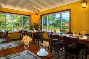 RosalieRosalie Bay Eco Resort & Spa的餐厅设有木桌、椅子和窗户。