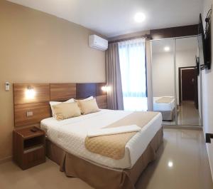 圣克鲁斯Premium Suites Deluxe Aparthotel Equipetrol的一间卧室配有一张大床和镜子